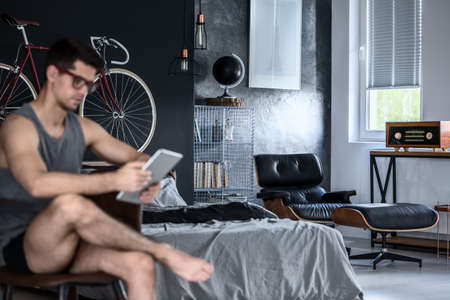 Handsome young man working from home on his tabletの写真素材