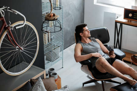 Handsome muscular man relaxing in his bedroom with yerba mateの写真素材