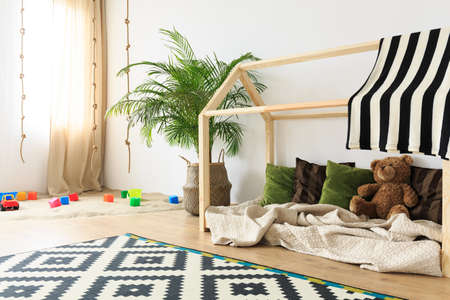 Modern designed baby room with wooden bed and plantsの写真素材