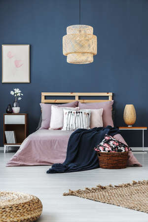 Dark blue blanket thrown on the bed with bright stylish bedding