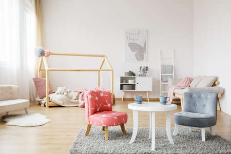 Two blue tea cups standing on white table in spacious kid roomの写真素材
