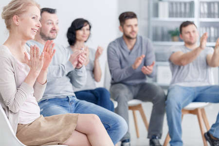 Happy people clapping at support group meetingの写真素材