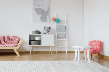 Kid room with small white table and rabbit patterned red chairの写真素材