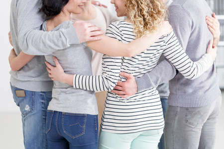 Psychotherapy group hugging after last meeting in rehabの写真素材