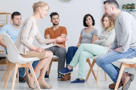 Talking with psychologist during group psychotherapy meeting