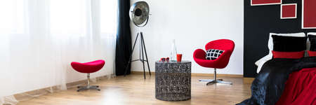 Two red chairs and big stylish lamp in modern apartmentの写真素材