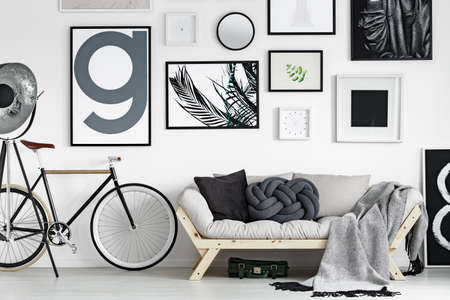 Vintage bike by wooden sofa in scandinavian style living room