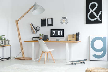 Study space with wooden desk and computer in cozy white room