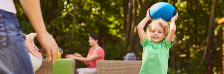 Little boy throwing ball with father during summer in the park