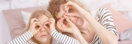 Happy mother and daughter imitating glasses, panoramaの写真素材