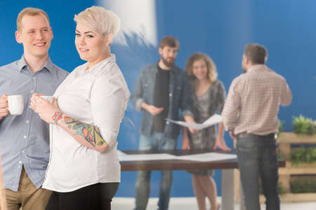 Couple of employees drinking coffee during a breakの写真素材