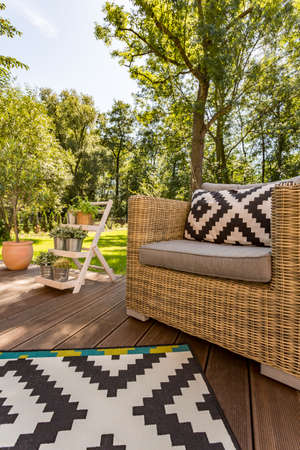 House terrace with a cosy armchair and the view of the garden