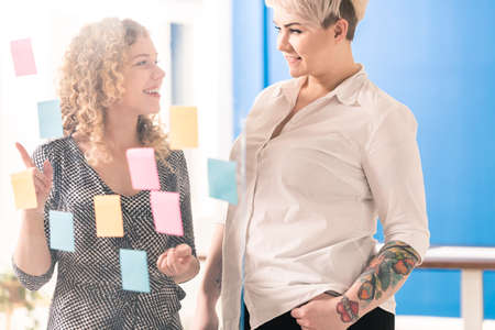 Two blond fimale coworkers brainstoriming at officeの写真素材