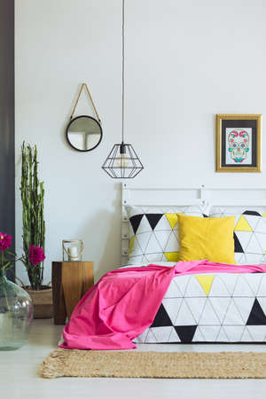 Geometric bedroom design, triangle quilt pattern, pink and yellow accessoriesの写真素材