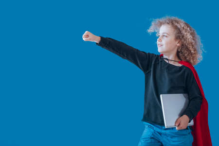 Boy dressed up as a superhero goes to robotic and programming classes, coding superhero conceptの写真素材