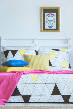 Scandinavian bedroom interior inspiration, colorful patterned bed in white roomの写真素材