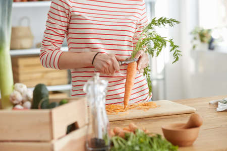 Woman making healthy carrot soup with bio vegetablesの写真素材