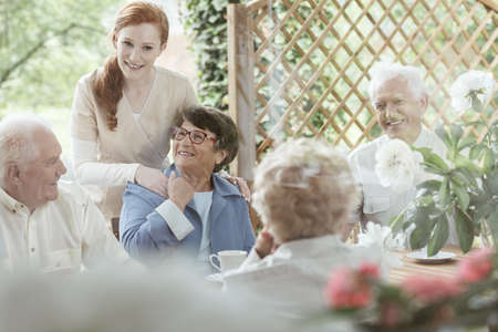 Volunteer supports an older woman while spending time together in the gardenの写真素材