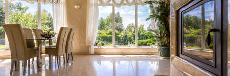 Lots of windows in dining room overlooking the gardenの写真素材