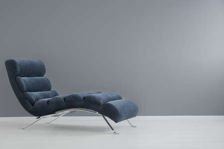Navy blue chaise lounge with metallic elements in spacious apartmentの写真素材