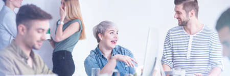 Young, happy people talking and joking at workの写真素材