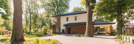 Big entrance with stone pathway to white and brown houseの写真素材