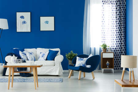 Blue and white spacious lounge with comfortable sofa and coffee tableの写真素材