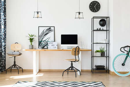 Minimalistic office design for remote workers with wooden chairs, potted plants and plain metal rackの写真素材