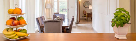 Wooden tabletop with fruits and with the view of dining roomの写真素材