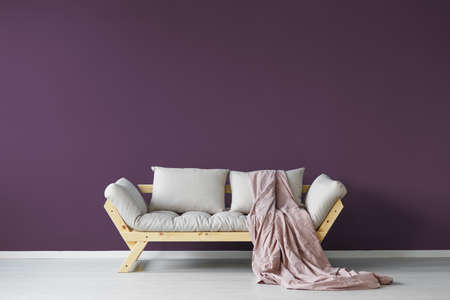 Violet day room interior with a cozy couch and a claret blanketの写真素材