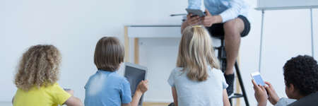 Kids with tablets and smartphones during modern computer science classesの写真素材