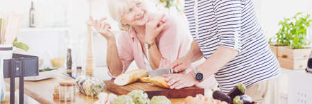Couple of happy seniors cooking lunch together in the kitchenの写真素材