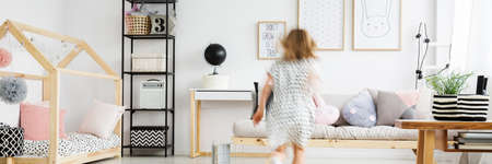 Blurred figure of girl playing in her stylish roomの写真素材