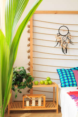 Bed shelf with apples and candles in ethnic designed bedroomの写真素材