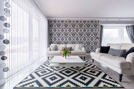 Elegant contemporary living room with white retro sofas and floral wallpaperの写真素材