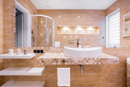 Sink in beige marble bathroom with relief on wall