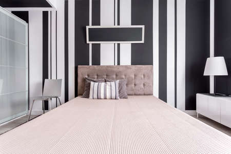 Central symmetrical view of bed with velvet headboard in fancy bedroom