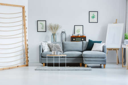 Hand made artwork in artist's living room with easel and posters of leaves on white wallの写真素材