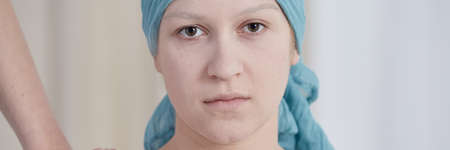 Young depressed woman with cancer wearing a blue scarfの写真素材