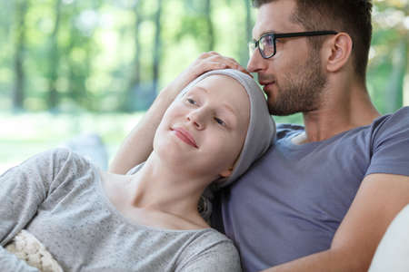Young loving couple supporting each other in her cancer treatmentの写真素材