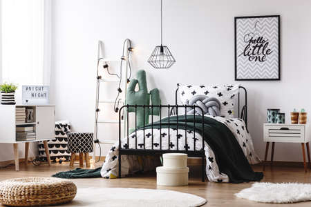 Braided pouf on white round carpet in scandi kids room with patterned stool next to bed