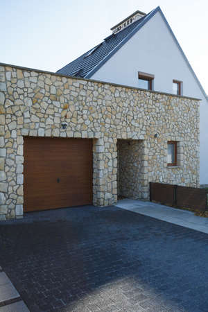 Wooden garage door and brick entrance of big modern houseの写真素材