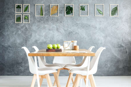 Collection of fresh leaves in wooden frames hanging on textured wallの写真素材