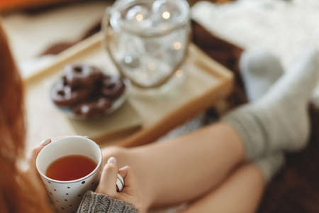 Woman sitting on the bed and holding mug with teaの写真素材