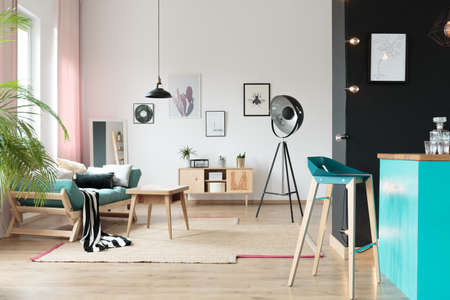 Striped black and white blanket on sofa in blue interior with designer barstool  and lampの写真素材