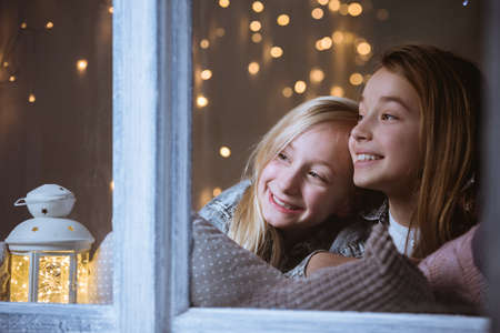 Happy, little friends looking out the window, at night