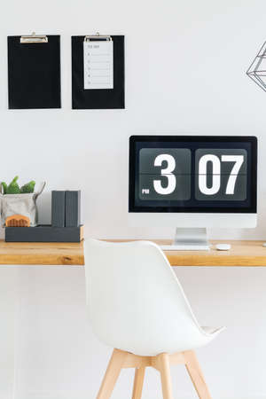 Digital desktop clock on computer screen in minimalist workspaceの写真素材