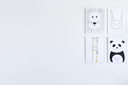Animal posters gallery on white wall in autistic child's bedroom, copy space interior concept
