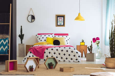 Colorful mexican bedroom with yellow pillow and patterned coverlet on king-size bed. Mexican bedroom conceptの写真素材