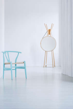 White hall leading to a bright living room with vintage blue armchairの写真素材